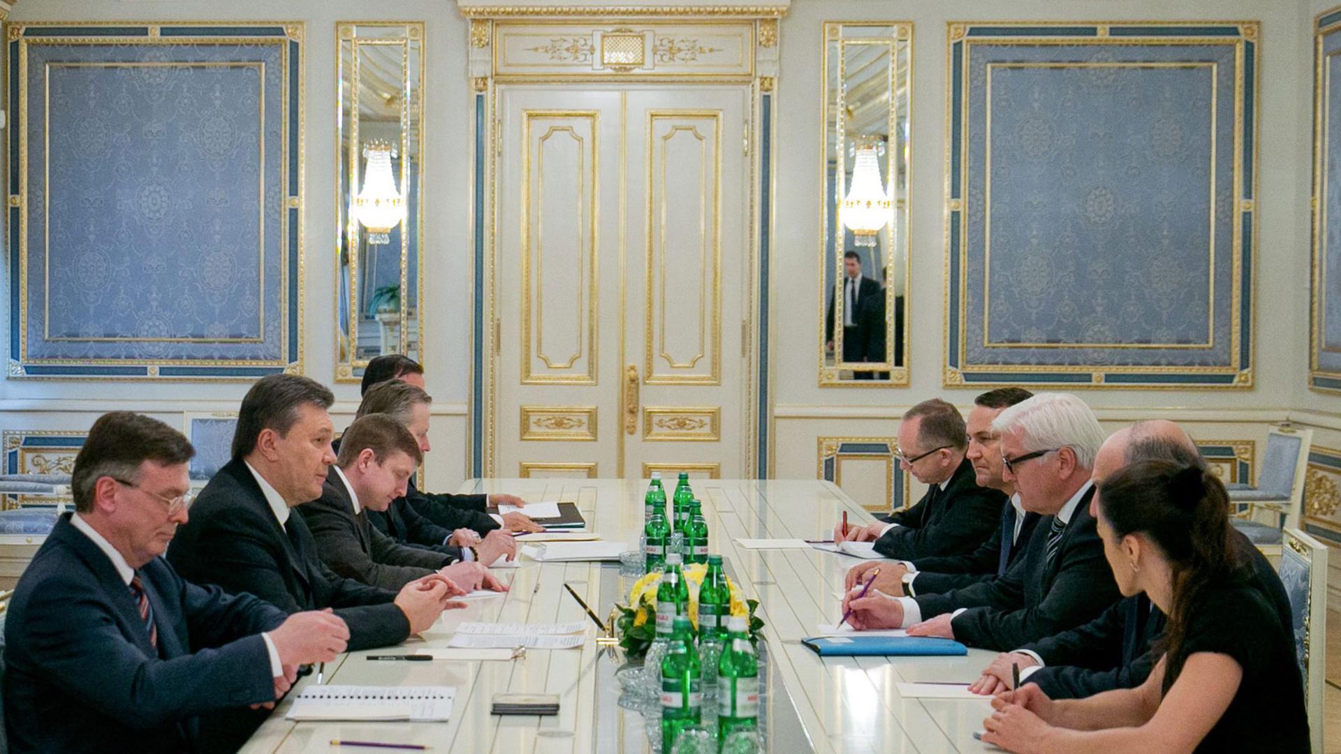 Die Außenminister Steinmeier, Fabius und Sikorski an einem Tisch mit Ministerpräsident Janukowitsch.