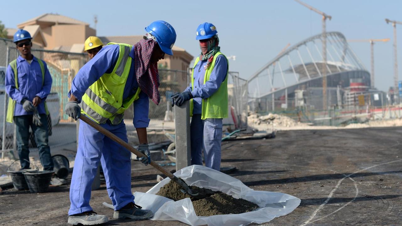 Gastarbeiter aus Indien und Bangladesch arbeiten vor dem Khalifa-Stadion in Doha, Katar. Im Vorfeld der WM 2022 in dem Golfstaat gibt es immer wieder Berichte über die Ausbeutung von Migranten auf den Stadion-Baustellen