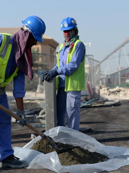 Gastarbeiter aus Indien und Bangladesch arbieten vor dem Khalifa-Stadion in Doha, Katar. Im Vorfeld der WM 2022 in dem Golfstaat gibt es immer wieder Berichte über die Ausbeutung von Migranten auf den Stadion-Baustellen