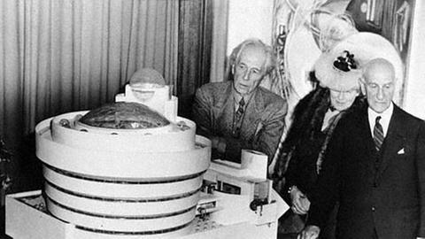 Der Architekt Frank Lloyd Wright, die Künstlerin Hilla von Rebay und Solomon R. Guggenheim betrachten ein Modell des New Yorker Guggenheim-Museums.