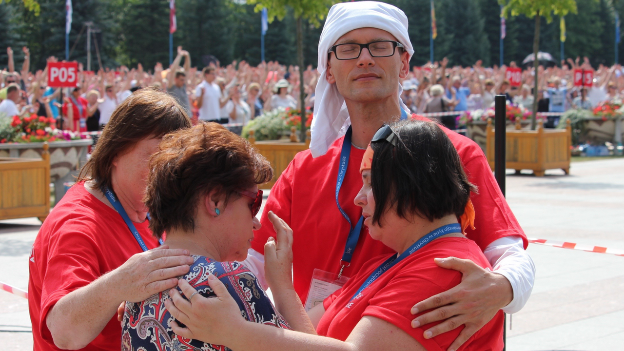 Neue religiöse Bewegungen geben Halt. Vier Menschen umarmen einander. 