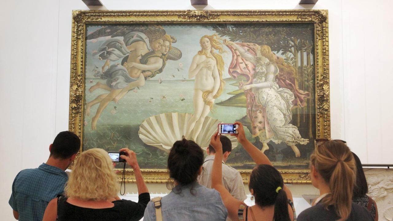 Besucher stehen vor dem Gemälde "Die Geburt der Venus" in den Uffizien in Florenz.