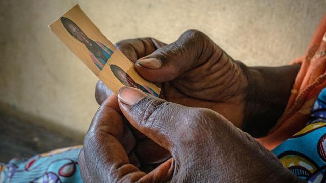 Eine Mutter in Conakry (Guineia) hält in ihren Händen das Foto ihres Sohnes, der die Reise nach Europa aus unbekannten Gründen nicht überlebte.
