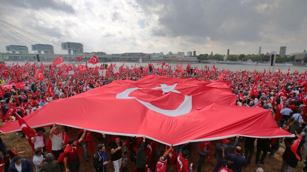 Anhänger des türkischen Staatspräsidenten Erdogan schwenken am 31.07.2016 in Köln (Nordrhein-Westfalen) türkische Fahnen. Mehrere Tausend Deutschtürken sind zu einer Pro-Erdogan-Demonstration in Köln zusammengekommen.