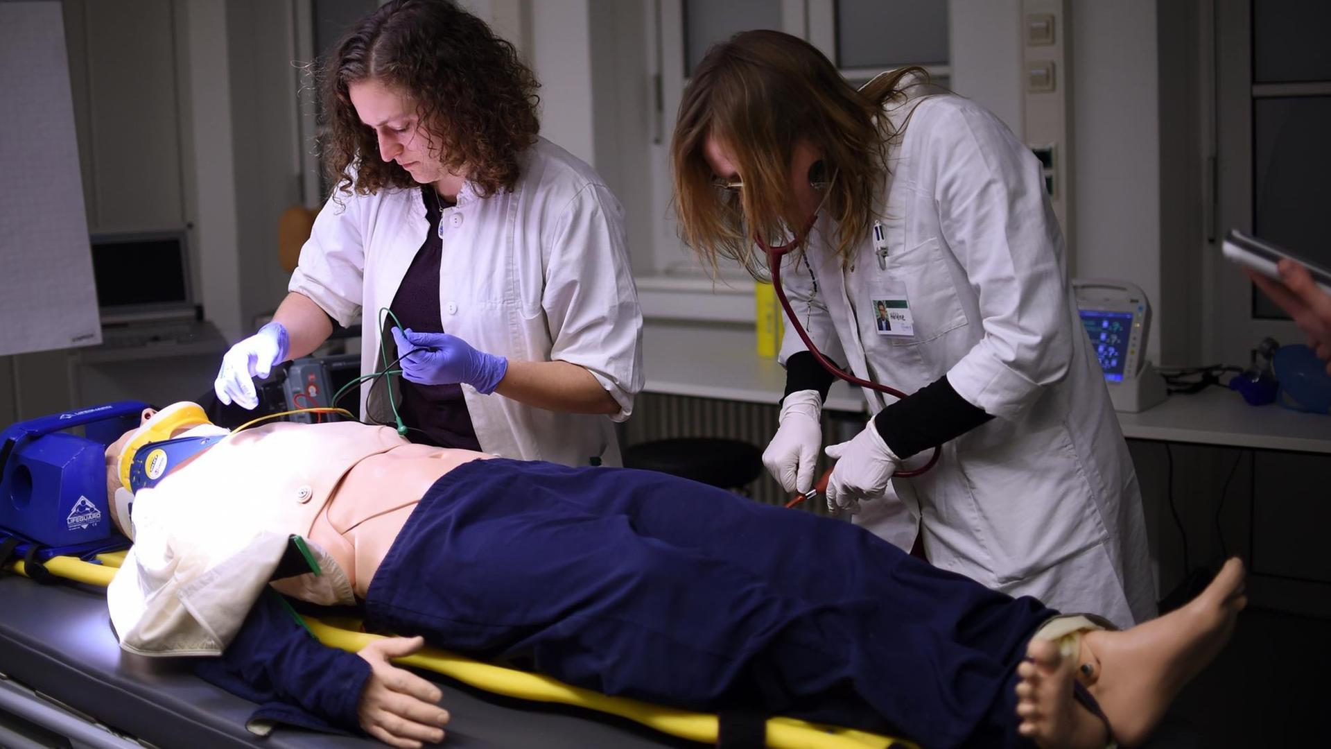 Medizinstudentinnen üben in der Berliner Charité an einer Puppe eine Notfallbehandlung.