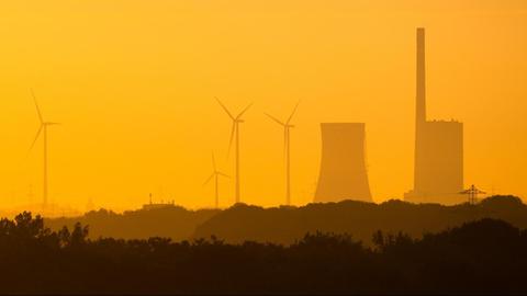 Die aufgehende Sonne taucht das Kohlekraftwerk Mehrum im Landkreis Peine am frühen Morgen in warmes Licht.