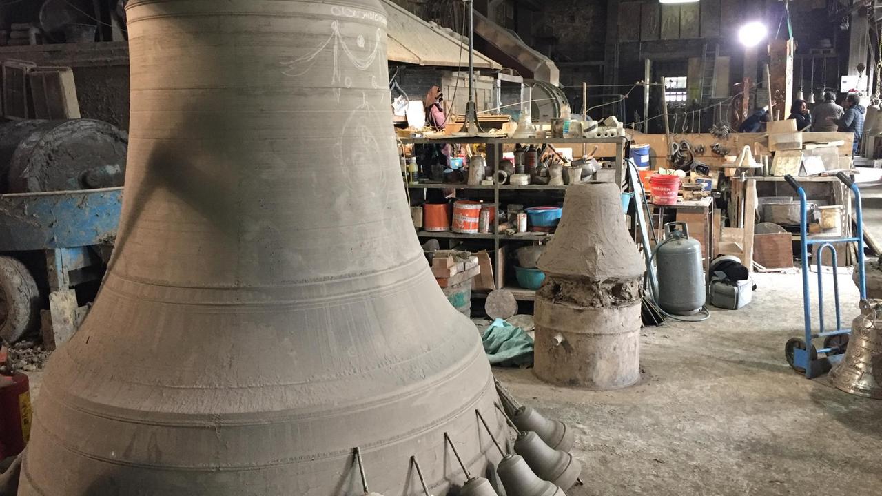 Ein Blick in die Glockengießerei der Marinellis - eine große Glocke steht im Vordergrund, zukünftige Ziselierungen mit Kreide angezeichnet. (Foto: Jan-Christoph Kitzler)