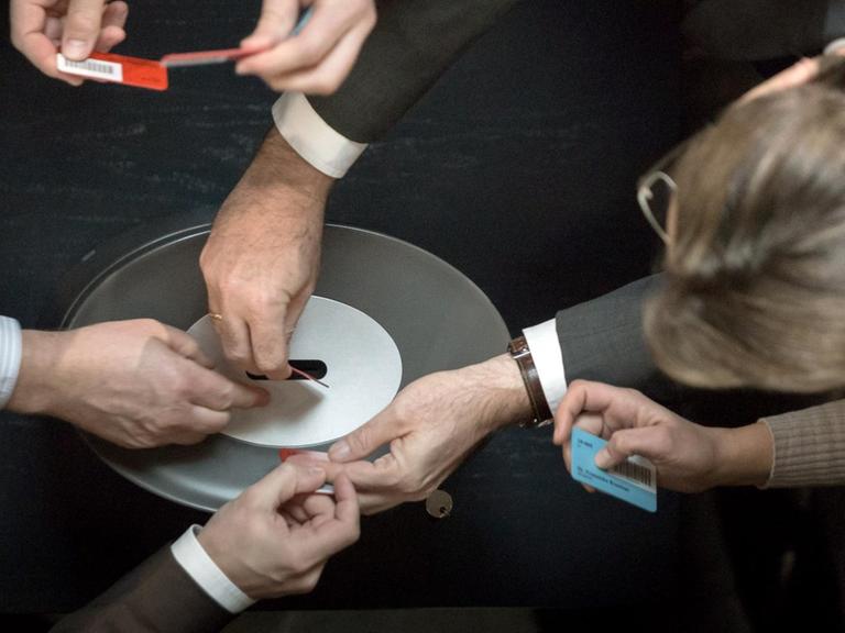 Namentliche Abstimmung von Parlamentariern mit Stimmkarten in die Wahlurne.