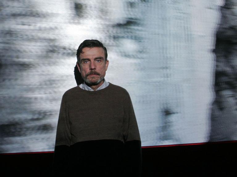 Der Videokünstler Marcel Odenbach vor einer seiner Arbeiten, die sich mit Erinnerungskultur beschäftigen