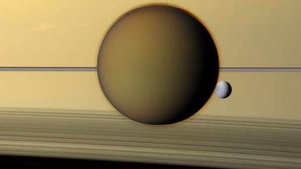 Schnappschuss der Cassini-Sonde: Die Monde Titan und Dione, die Ringe, ihr Schatten und die Wolken des Planeten