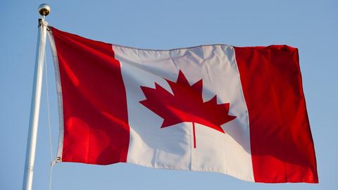 Die Landesfahne von Kanada weht am blauen Himmel