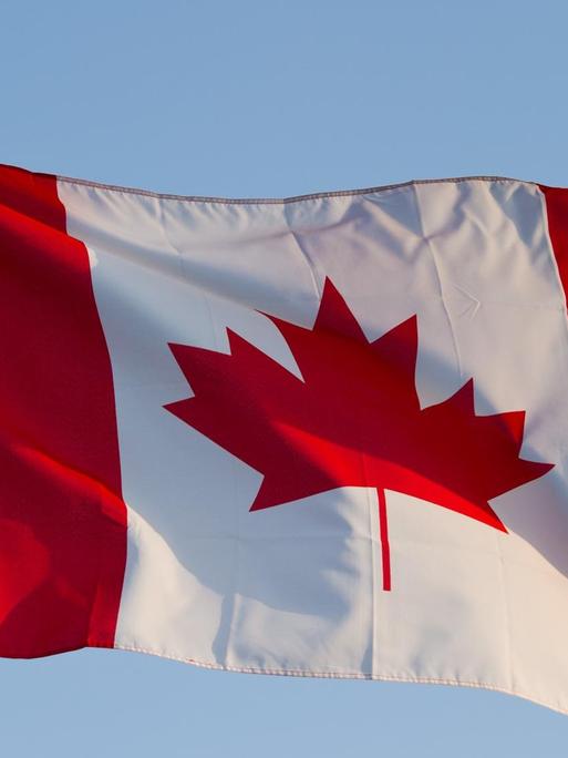Die Landesfahne von Kanada weht am blauen Himmel