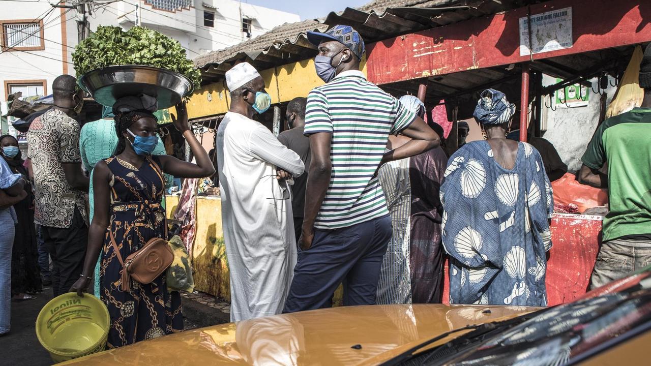 Senegalesen mit Atemschutzmasken beim Einkaufen auf einem Markt in Dakar.
