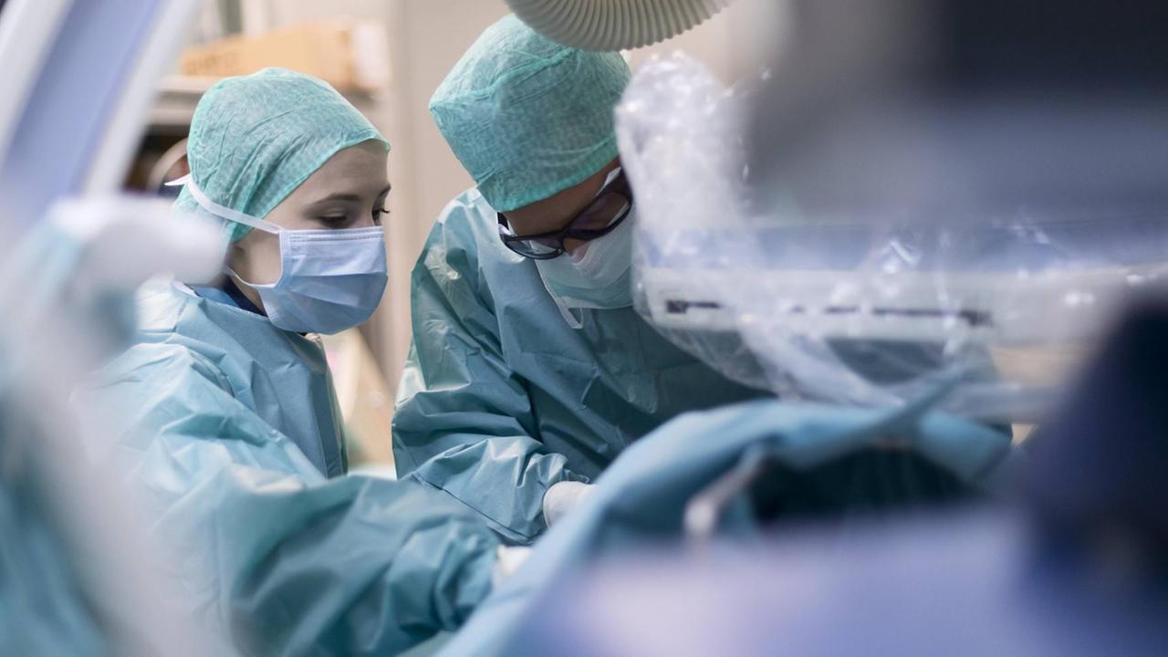 Zwei Ärzte hantieren in einem Operationssaal