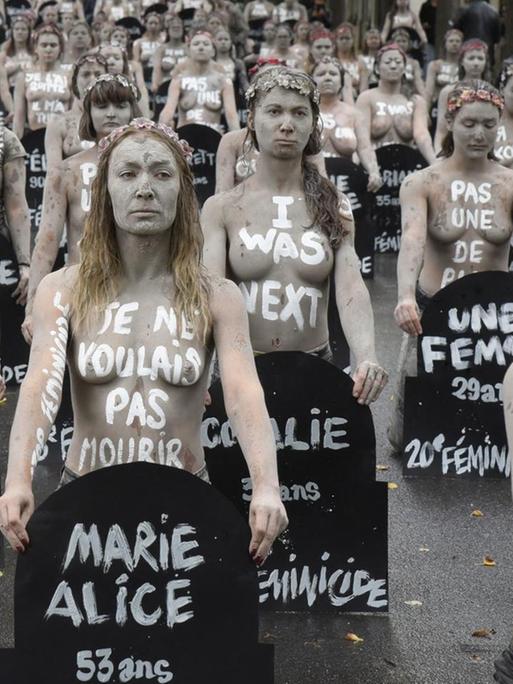 Weiss geschminkte Femen Aktivistinnen mit nacktem Oberkörper halten auf dem Friedhof Montparnasse in Paris Grabschilder von Frauen in den Händen, die durch Männergewalt gestorben sind. Jedes Grabschild zeigt den Namen und das Alter der Frau, die durch ihren Partner oder Ex-Partner ermordet worden ist. Eine Demonstration am 5. Oktober 2019.