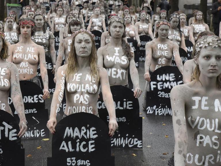 Weiss geschminkte Femen Aktivistinnen mit nacktem Oberkörper halten auf dem Friedhof Montparnasse in Paris Grabschilder von Frauen in den Händen, die durch Männergewalt gestorben sind. Jedes Grabschild zeigt den Namen und das Alter der Frau, die durch ihren Partner oder Ex-Partner ermordet worden ist. Eine Demonstration am 5. Oktober 2019.