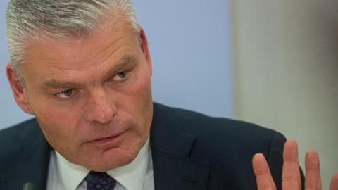 Holger Stahlknecht mit leicht erhobenen Händen bei einer Pressekonferenz