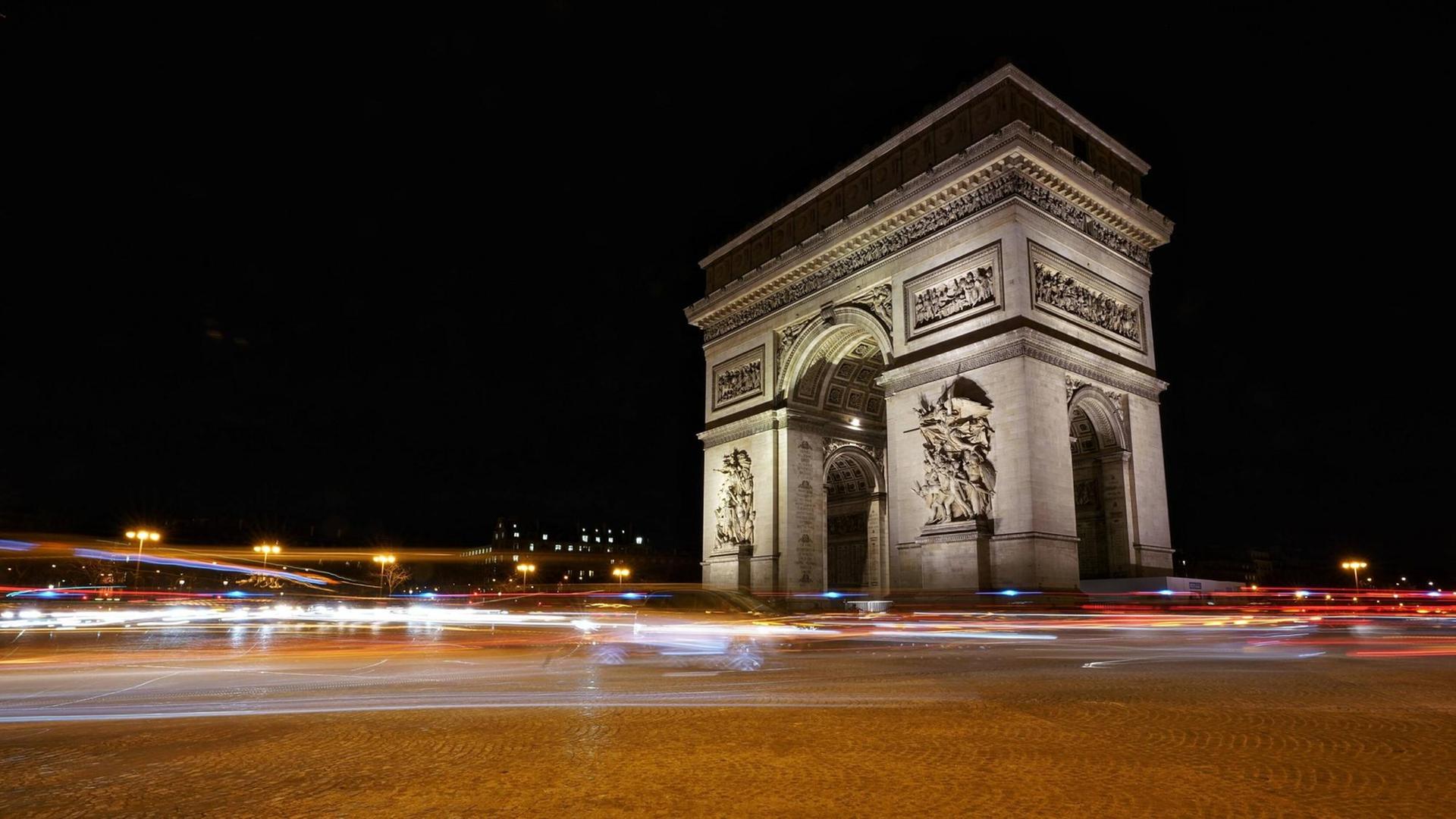 Das Foto zeigt den Triumphbogen in Paris in der Nacht.