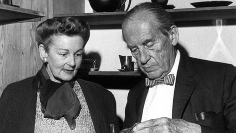 Der Architekt Walter Gropius betrachtet mit seiner Frau Ise während der Eröffnung des von ihm angeregten Bauhaus-Archivs im Ernst-Ludwig-Haus auf der Darmstädter Mathildenhöhe am 8. April 1961 eine Metallkanne aus den Bauhaus-Werkstätten.