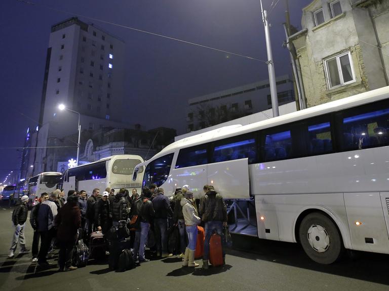 Rumänen warten vor einem Bus nach Deutschland