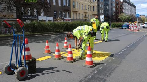 "Spurmacher" malen auf eine Straße in Berlin einen neuen Fahrradstreifen.