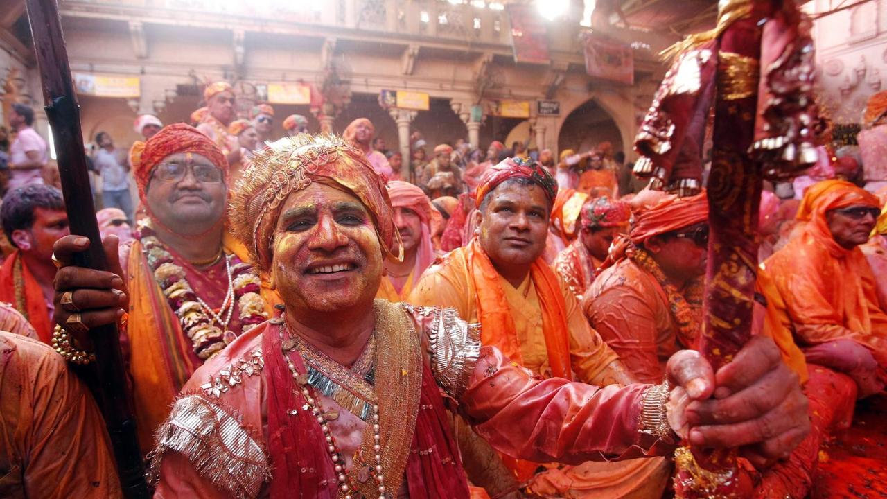 Hinduistische Männer feiern das Holi-Fest in Barsana, Indien. In Barsana feiern Menschen das "Lathmar" Holi, eine Variation des klassichen Holi-Festes. 