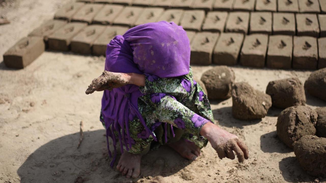 Ein afghanisches Mädchen arbeitet in einer Ziegefabrik.
