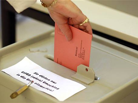 Eine Frau wirft im Wahlamt in Bremen ihren Stimmzettel in die Wahlurne.