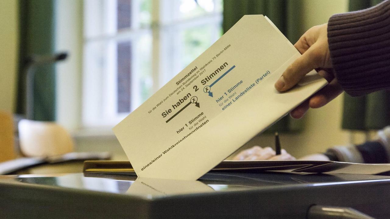 Eine Wählerin wirft bei der Bundestagswahl 2017 einen Stimmzettel in eine Urne