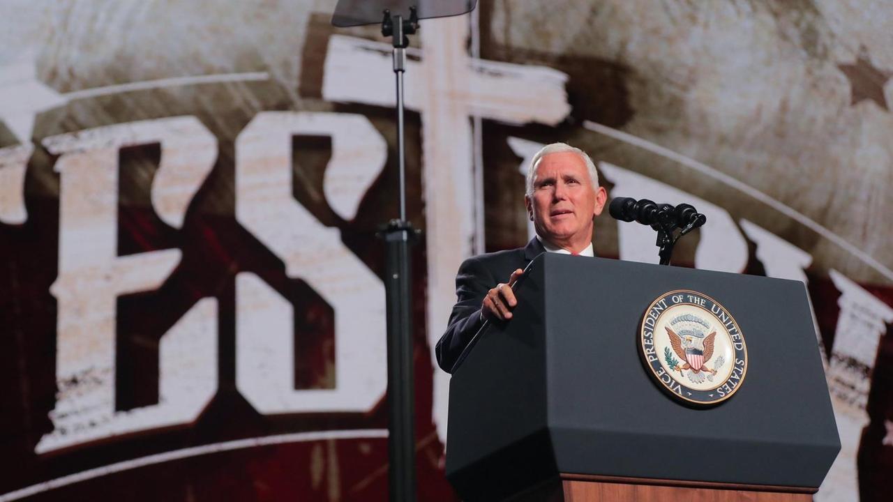 Mike Pence am Rednerpult, im Hintergrund ein Kreuz in einem Schriftzug