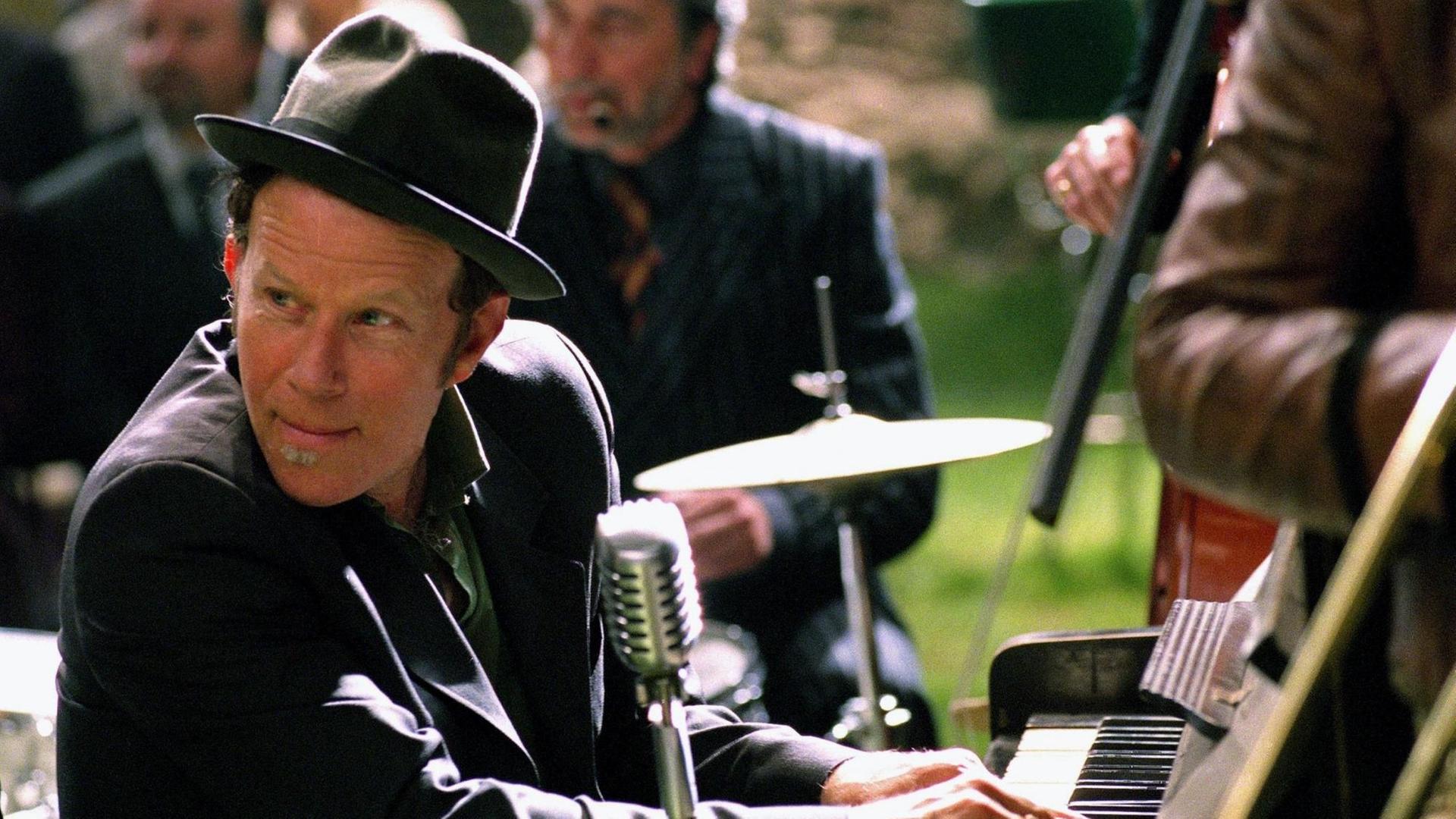 Schauspieler und Musiker Tom Waits sitzt mit Hut bekleidet an einem Klavier in dem Film "Der Tiger und der Schnee" aus dem Jahr 2005.