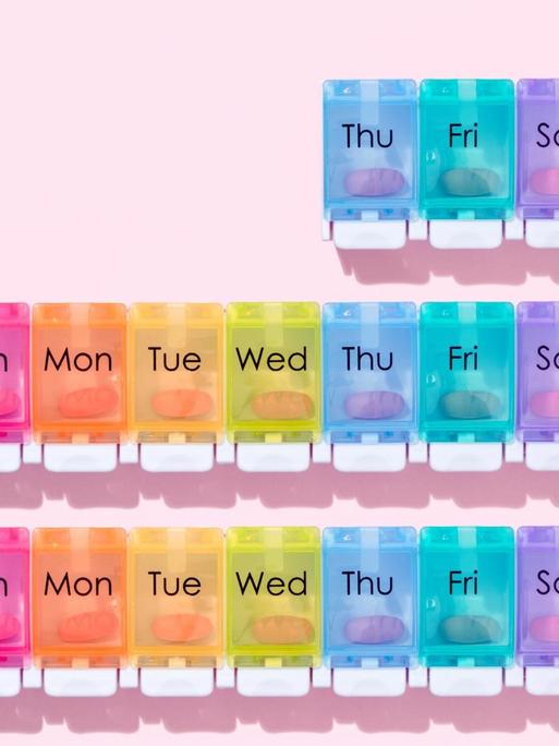 Illustration von Wochen-Pillenschachtel auf rosa Hintergrund.