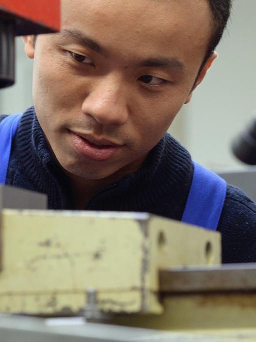 Zwei vietnamesische Arbeiter bei ihrer Ausbildung zu Mechatronikern in Chemnitz - Deutschland bleibt bei Zuwanderern beliebt.