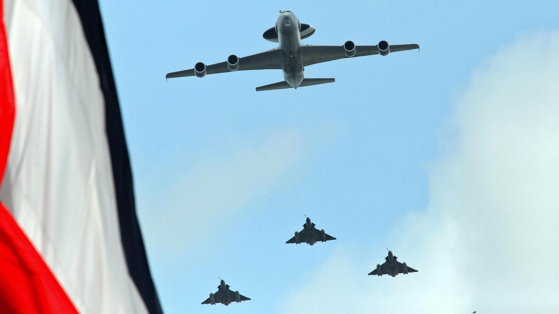 Französische Militär-Flugzeuge fliegen an einer Flagge vorbei