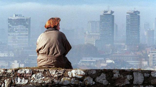 Ein Bild aus dem Jahr 1995 zeigt eine Frau, die auf die Skyline von Sarajevo blickt.