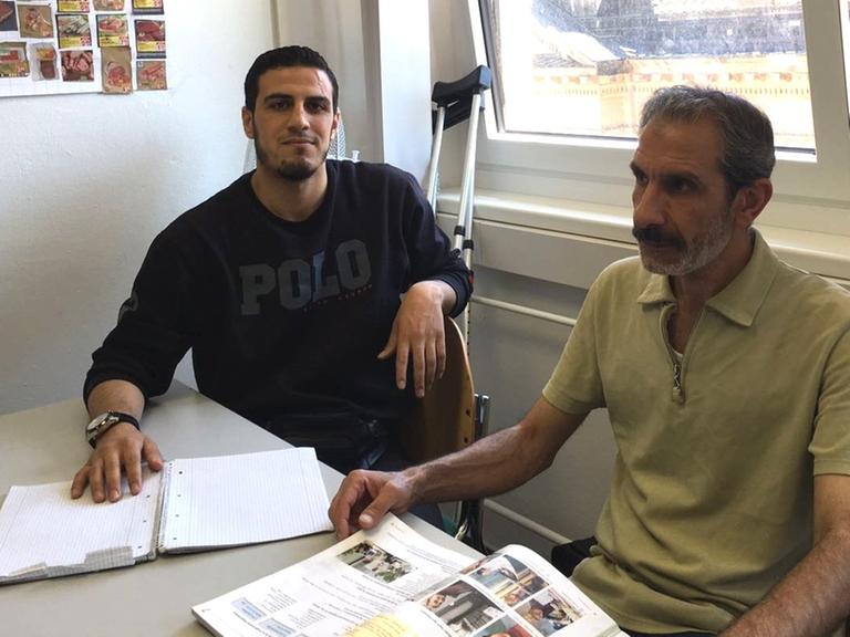 Die beiden Syrer Karim und Mazen sitzen in einer Berliner Sprachschule, um Deutsch zu lernen.