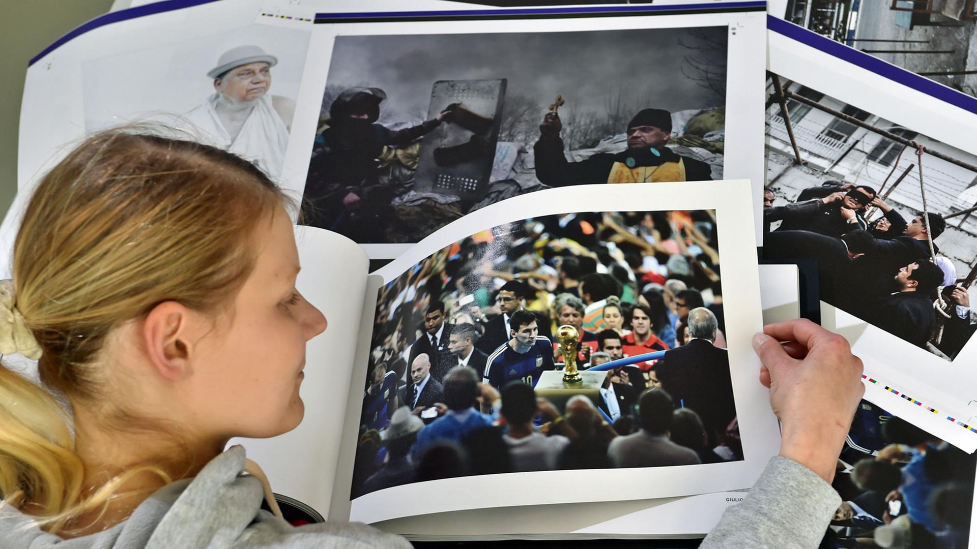Im Printlabor der Technischen Universität in Chemnitz blättert eine Studentin am 28.04.2015 in einem Buch mit integrierten Lautsprechern. Das sogenannte T-book (Ton-Buch) zeigt die Bilder des World Press Photo Awards und bringt diese zum Klingen.