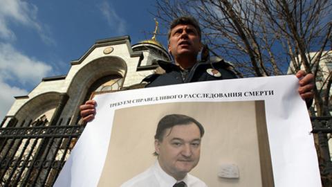 Boris Nemtsow von der Freiheitspartei protestiert vor dem russischen Innenministerium mit einem Foto des in U-Haft gestorbenen Anwalts Sergej Magnitski.