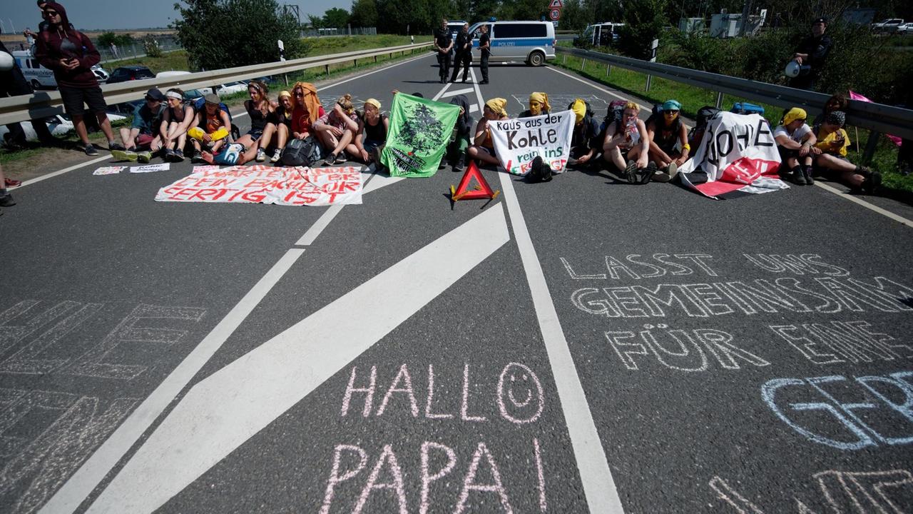 Mitglieder der Aktionsgruppe "Kohle erSetzen!" blockieren eine Straße, die zum Braunkohletagebau Garzweiler führt