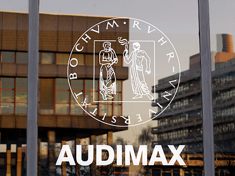 wei Gebäude der Ruhruniversität in Bochum spiegeln sich in der Glasfassade des Audimax.