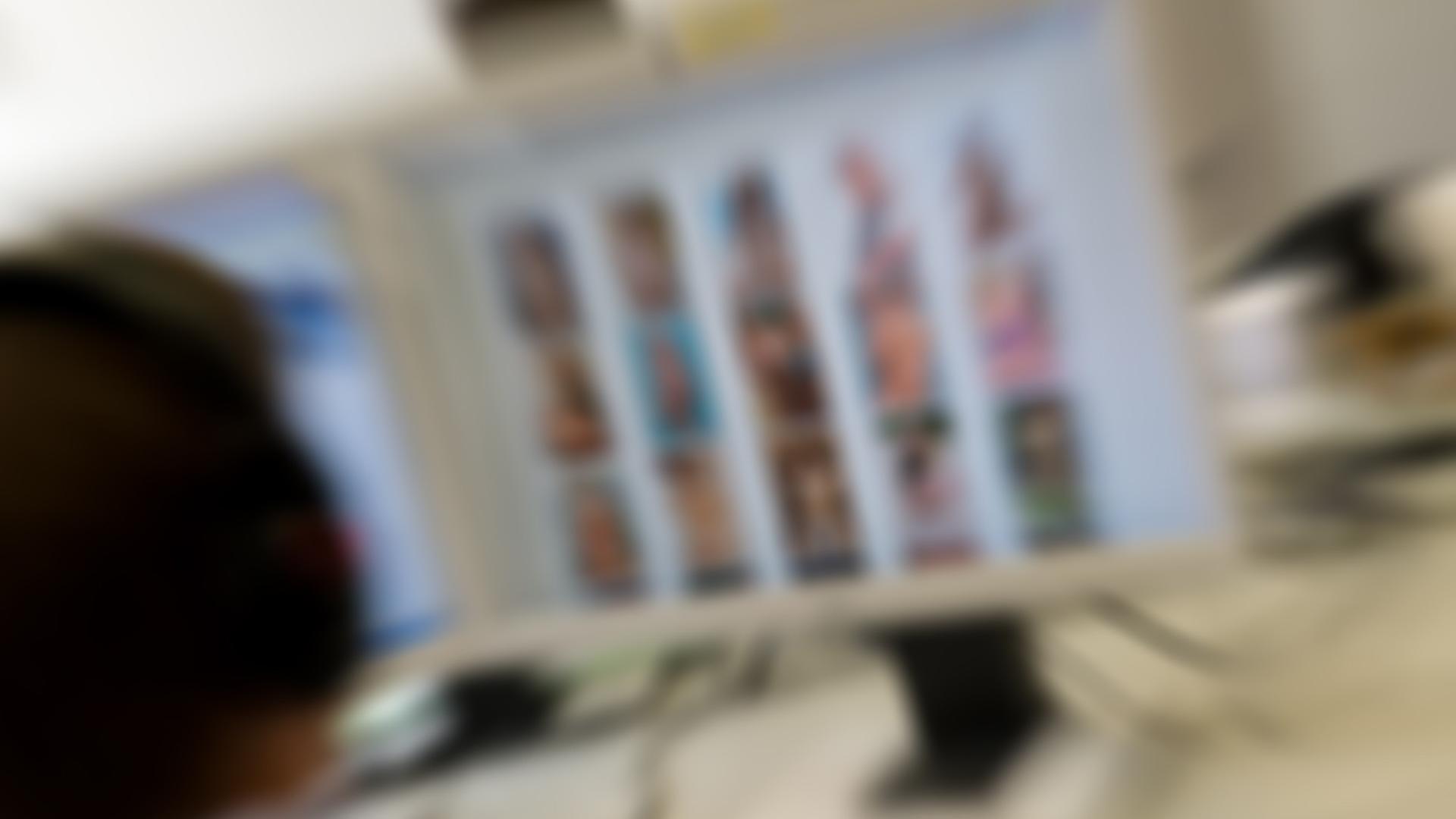 Verschwommene Aufnahme eines Polizei-Computers mit kinderpornografischen Bildern auf dem Bildschirm. Davor von hinten der Kopf des Polizisten. Verschwommene Aufnahme eines Polizei-Computers mit kinderpornografischen Bildern auf dem Bildschirm. Davor von hinten der Kopf des Polizisten.
