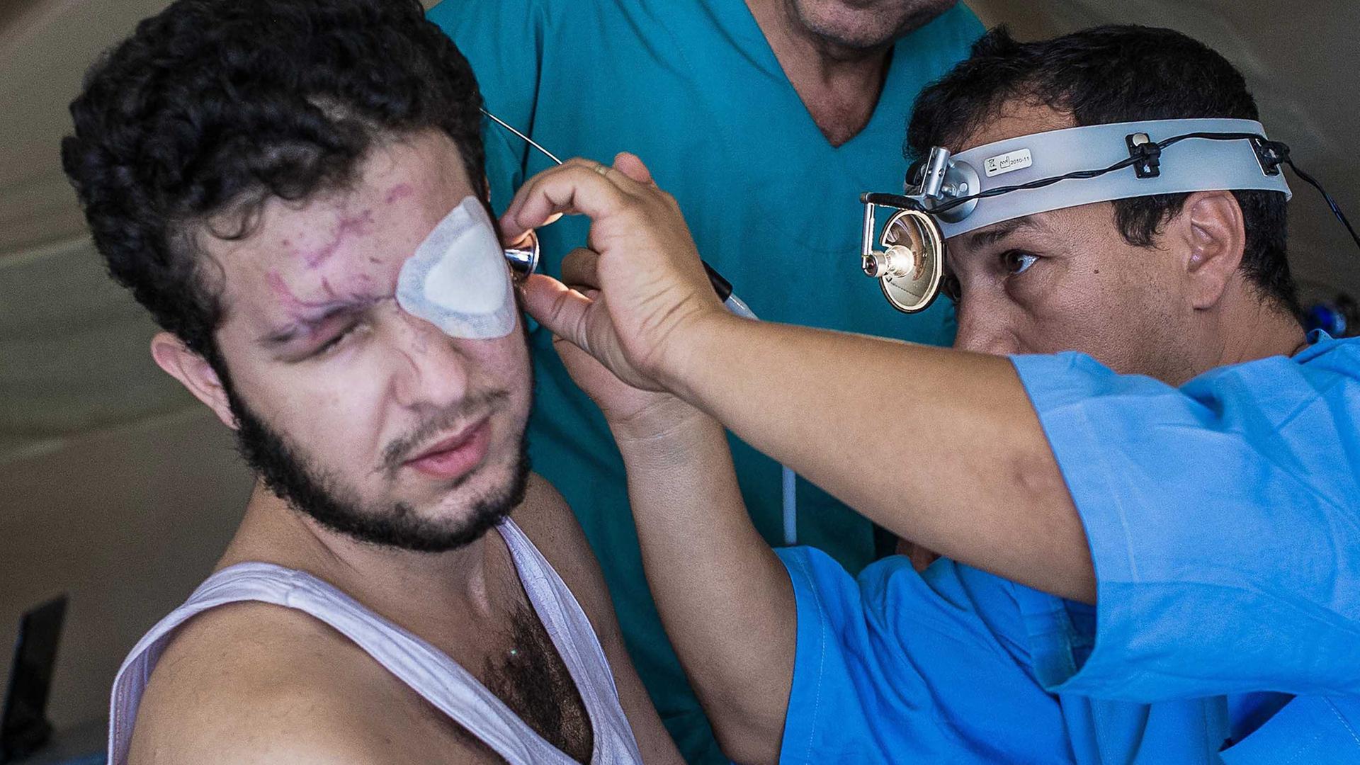 Ein Syrer wird von einem Sanitäter in einer Sanitätsstation behandelt.