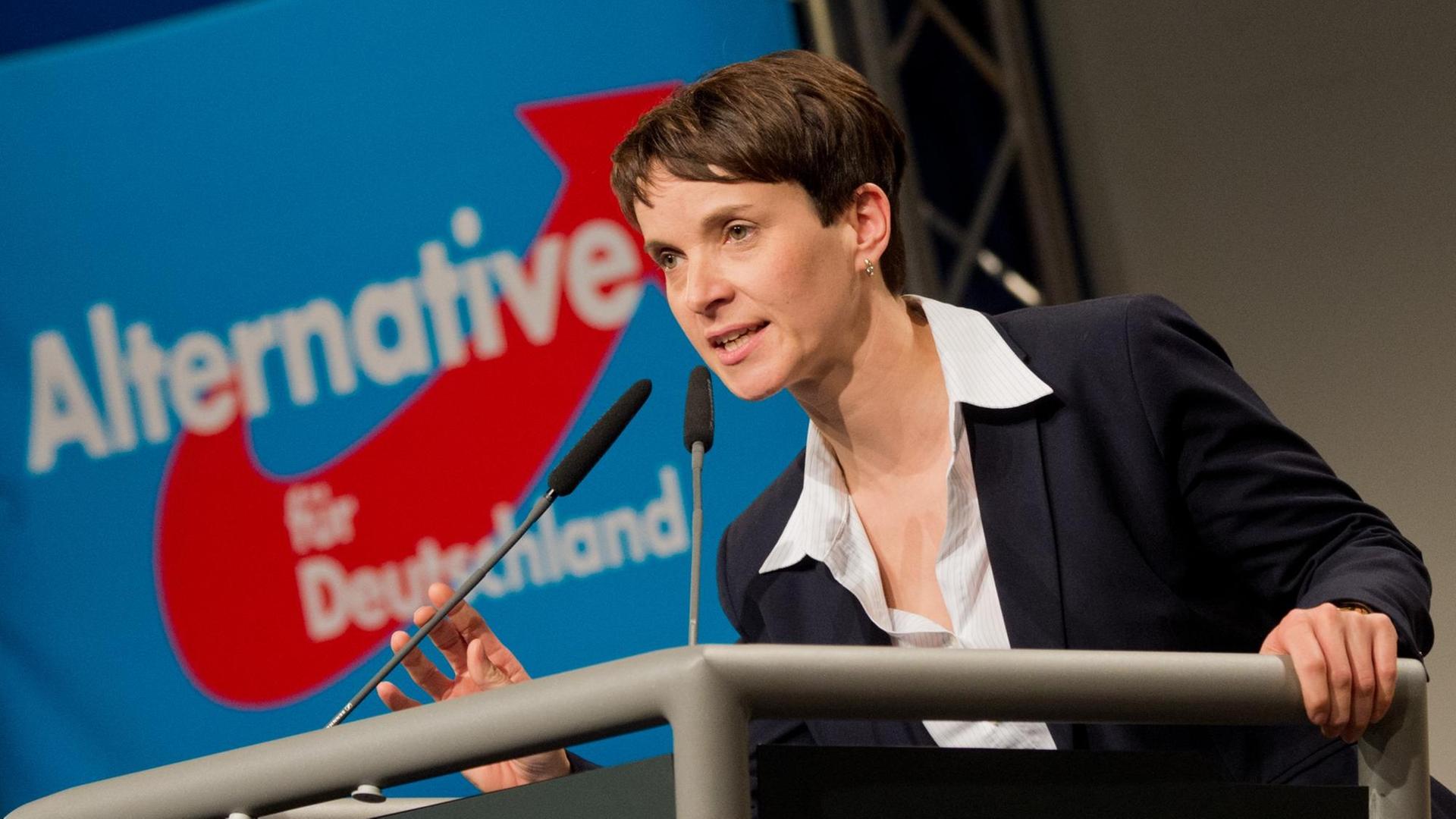 Zu sehen ist die AfD-Vorsitzende Frauke Petry am Rednerpult, hinter ihr der blau-weiß-rote Schriftzug der Partei.
