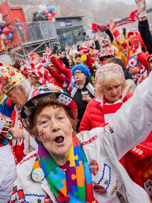 Viele kostümierte Menschen stehen dicht nebeneinander und feiern.