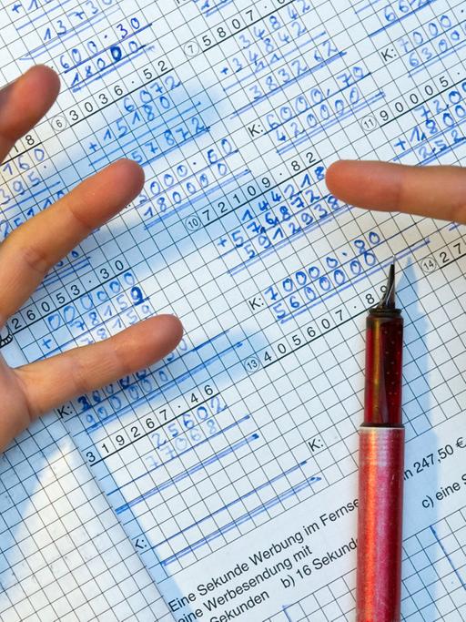 Ein Grundschüler nimmt bei den Hausaufgaben im Fach Mathematik seine Finger zur Hilfe.