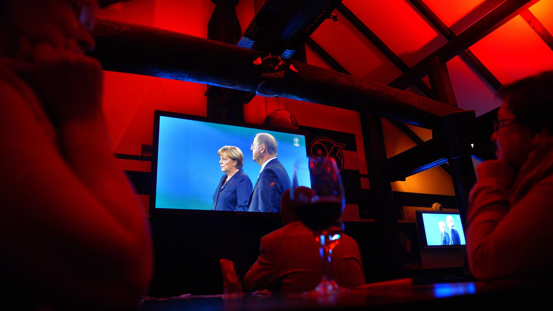 Menschen verfolgen auf einer SPD-Wahlkampfveranstaltung in Hannover das Fernsehduell zwischen Bundeskanzlerin Angela Merkel, CDU, und dem Spitzenkandidaten Peer Steinbrück, SPD, auf einem Display; Aufnahme vom September 2013