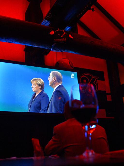 Menschen verfolgen auf einer SPD-Wahlkampfveranstaltung in Hannover das Fernsehduell zwischen Bundeskanzlerin Angela Merkel, CDU, und dem Spitzenkandidaten Peer Steinbrück, SPD, auf einem Display; Aufnahme vom September 2013