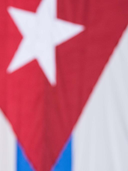 US-Präsident Barack Obama steht vor einer kubanischen und einer US-Flagge.
