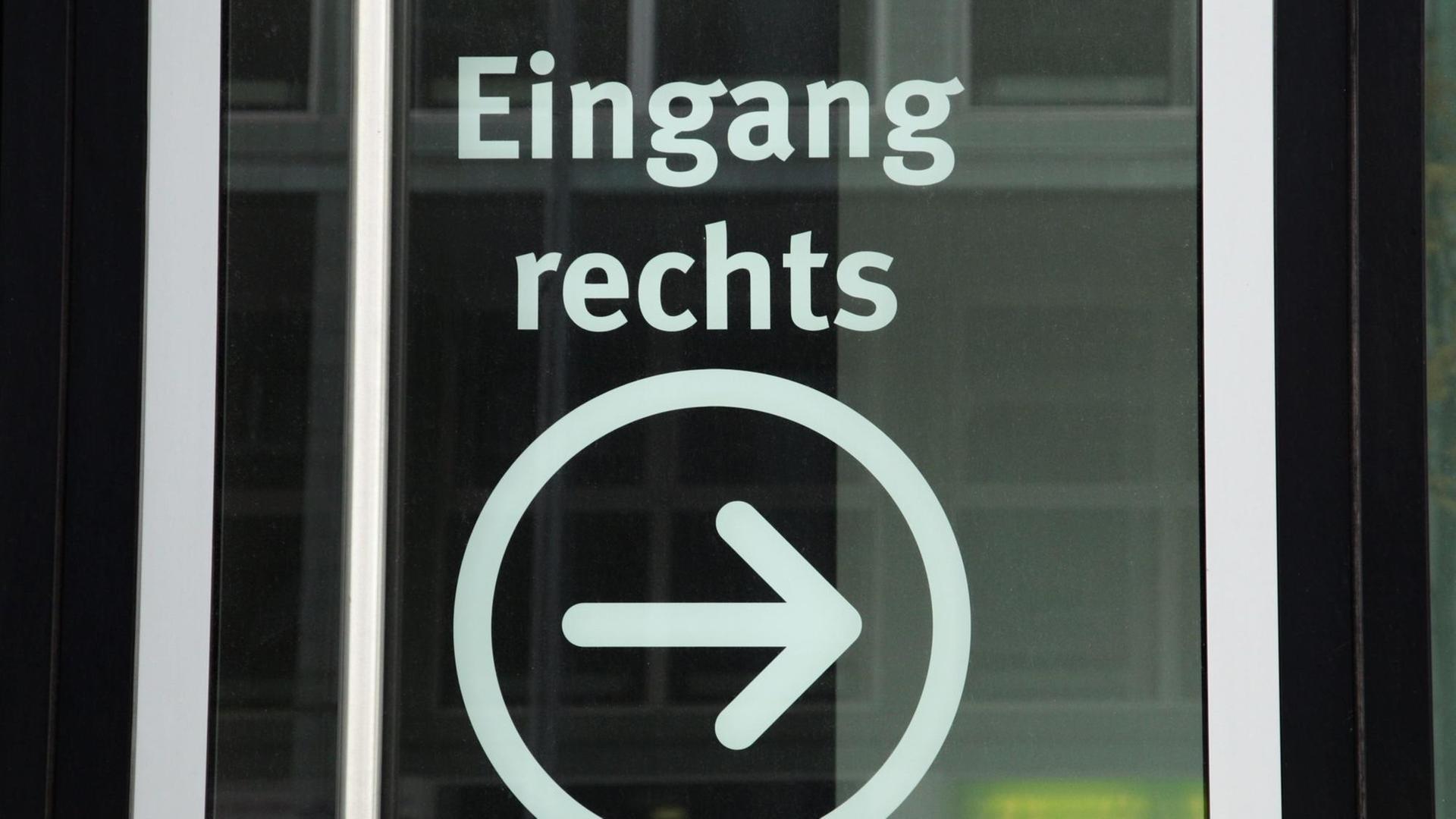 Auf einer Glastür steht "Eingang rechts" mit einem eingekreisten Pfeil