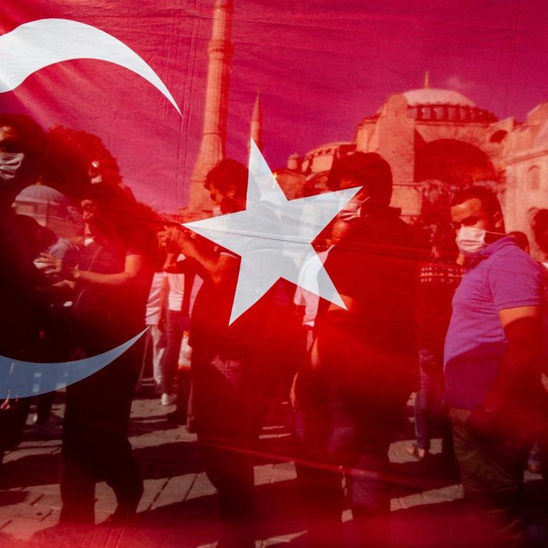 Menschen freuen sich hinter einer türkischen Nationalflagge vor der Hagia Sophia über die Gerichtsentscheidung zur Umwandlung der Hagia Sophia von einem reinen Museum in eine Moschee.